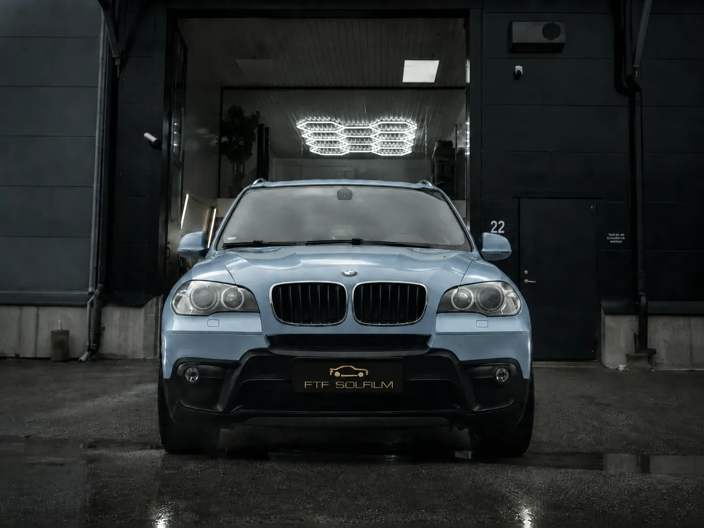 Ljusblå BMW SUV med tonade rutor och solfilm framför FTF Solfilm i Stockholm